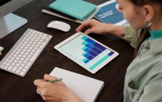 Business professional analyzing a bar graph on a tablet showcasing debt management strategies for business growth