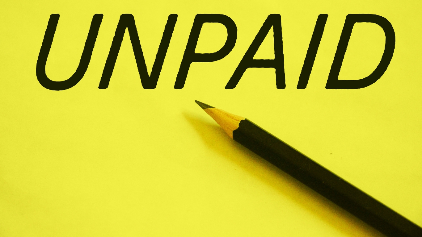 Unpaid Invoices: Close-up image of a pencil on yellow paper with the word "UNPAID" written on it.