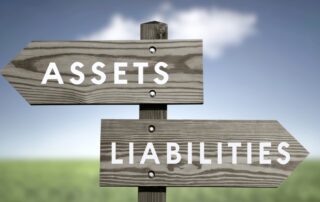 Asset and Liability Reports: Two wooden road signs pointing in opposite directions, one labeled "Assets" and the other labeled "Liabilities".