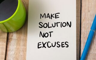 Positive Client Relationships: Text on notepad reads "Make Solutions Not Excuses". Motivational message for positive client relationships in debt collection.