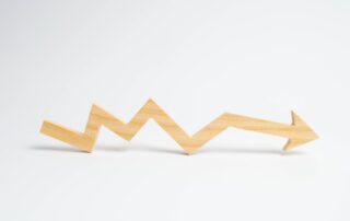 Wooden arrow pointing upwards, representing increasing bad debt.