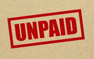 Unlock Hidden Capital: Red rubber stamp with the word "UNPAID" in black ink for outstanding invoices or overdue bills.