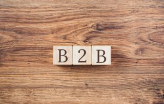 Recovering B2B Debt: Wooden blocks with "B2B" on a wooden table, representing business-to-business debt recovery in the real estate sector.
