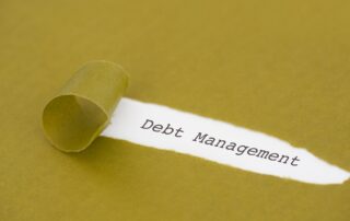 Avoid Costly Debt: Torn yellow paper revealing the words "Debt Management," representing the need to address and manage debt.