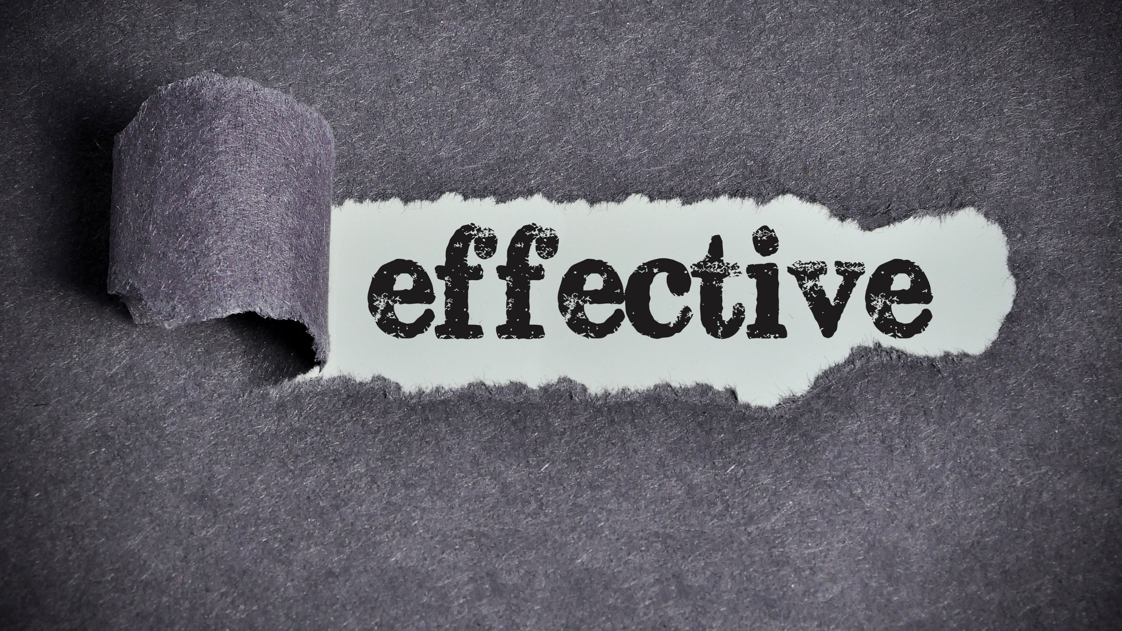Effective Debt Collection: A close-up photo of a ripped piece of paper revealing the word "effective" in bold letters, emphasizing the importance of effective debt collection strategies for businesses.