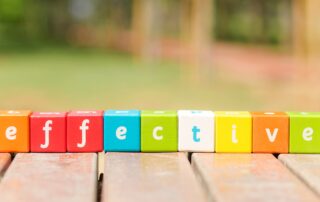 Recovering B2B Debt: Colorful blocks spelling "effective" on a wooden surface, representing effective debt recovery solutions for the real estate industry.
