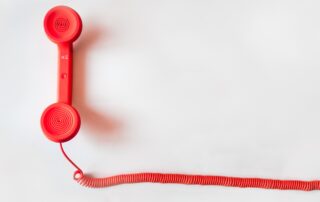 Beyond Phone Call: A red phone on a white background, symbolizing traditional communication methods in debt collection.