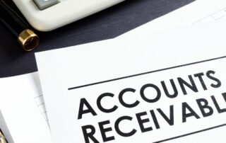 Monthly Accounts Receivables: Documents and calculator on desk, focusing on "Accounts Receivable" text.