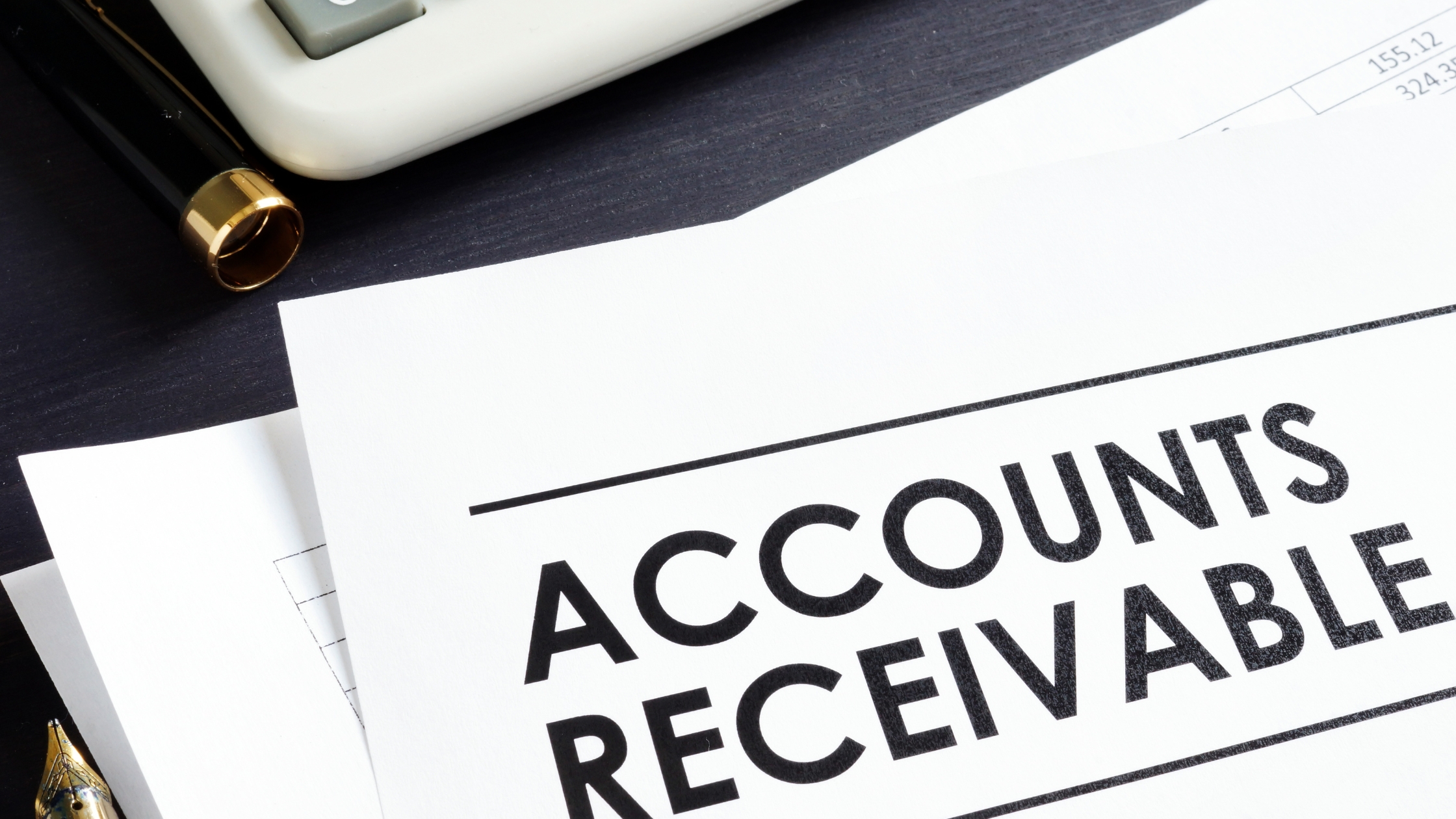 Monthly Accounts Receivables: Documents and calculator on desk, focusing on "Accounts Receivable" text.