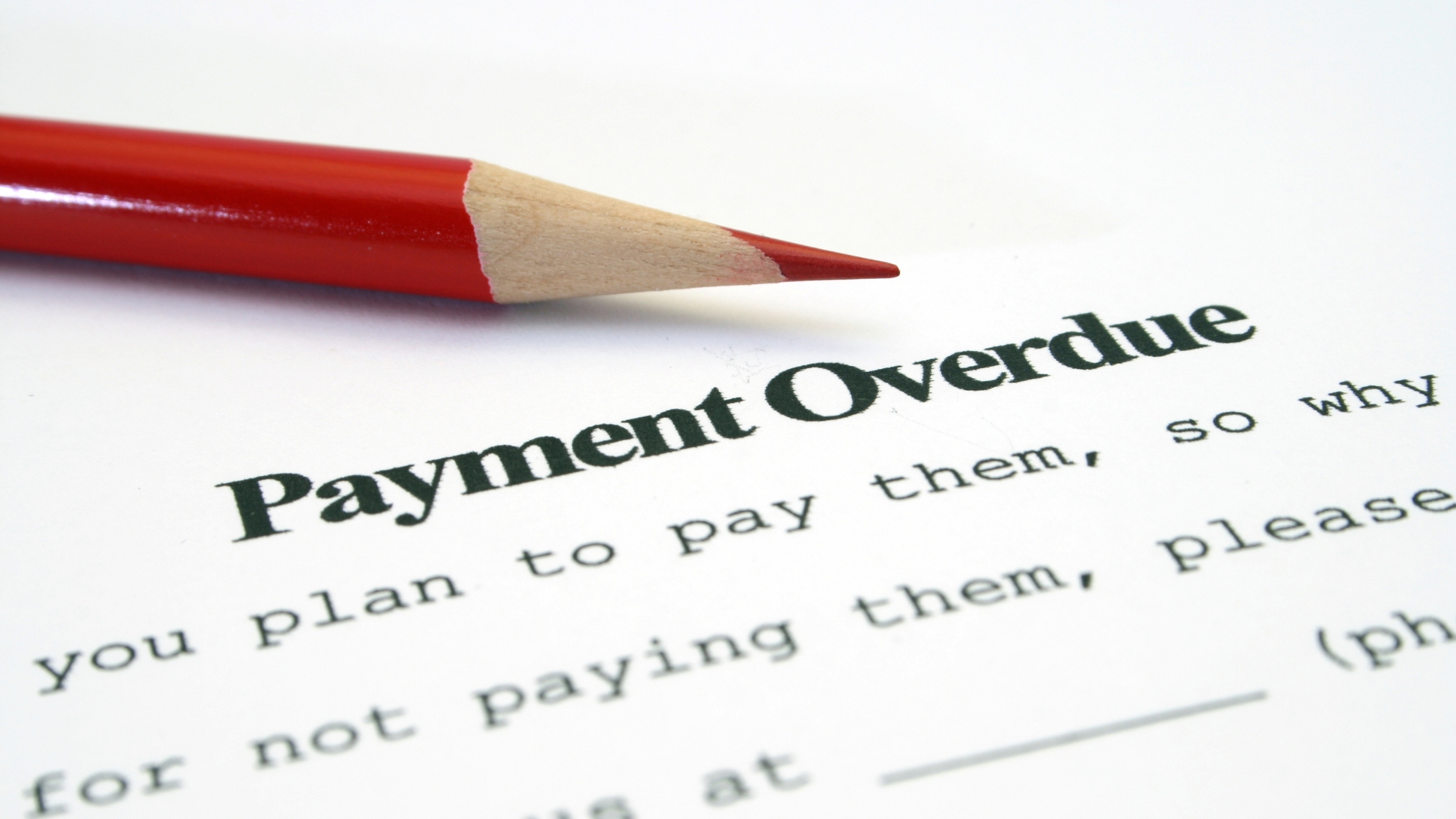 Commercial Debt Collection: A red pencil points to the words "Payment Overdue" on a debt collection notice, highlighting the need for innovative AI-driven solutions to improve commercial debt recovery.