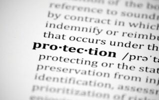 Business Debt Collection: Close-up of dictionary definition highlighting the word "protection," emphasizing the safeguarding of consumer rights during debt collection.